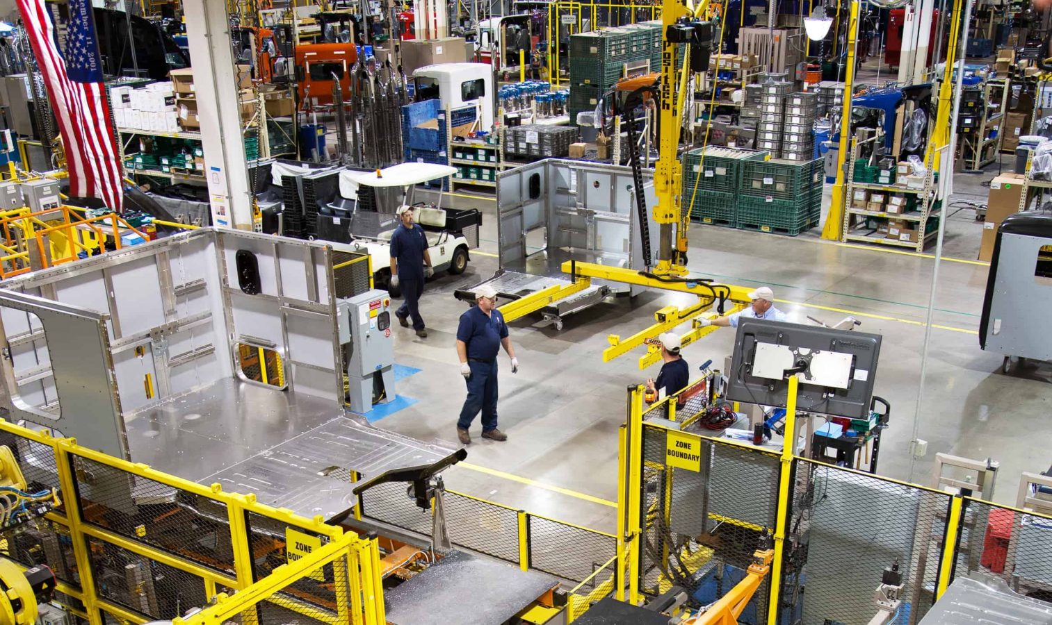 Manufacturing workers walk on the shopfloor.