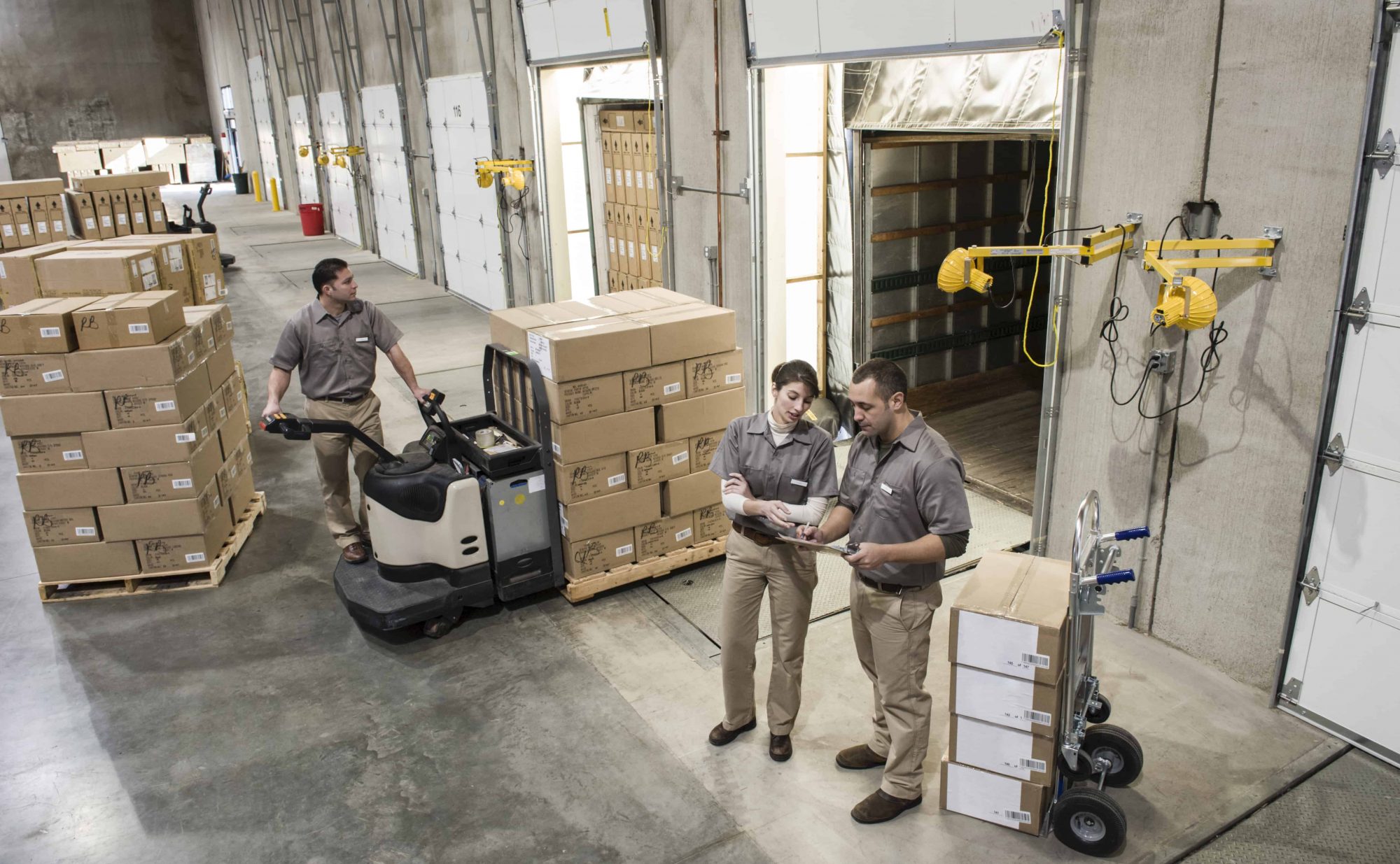 Manufacturing workers move boxes out of warehouse