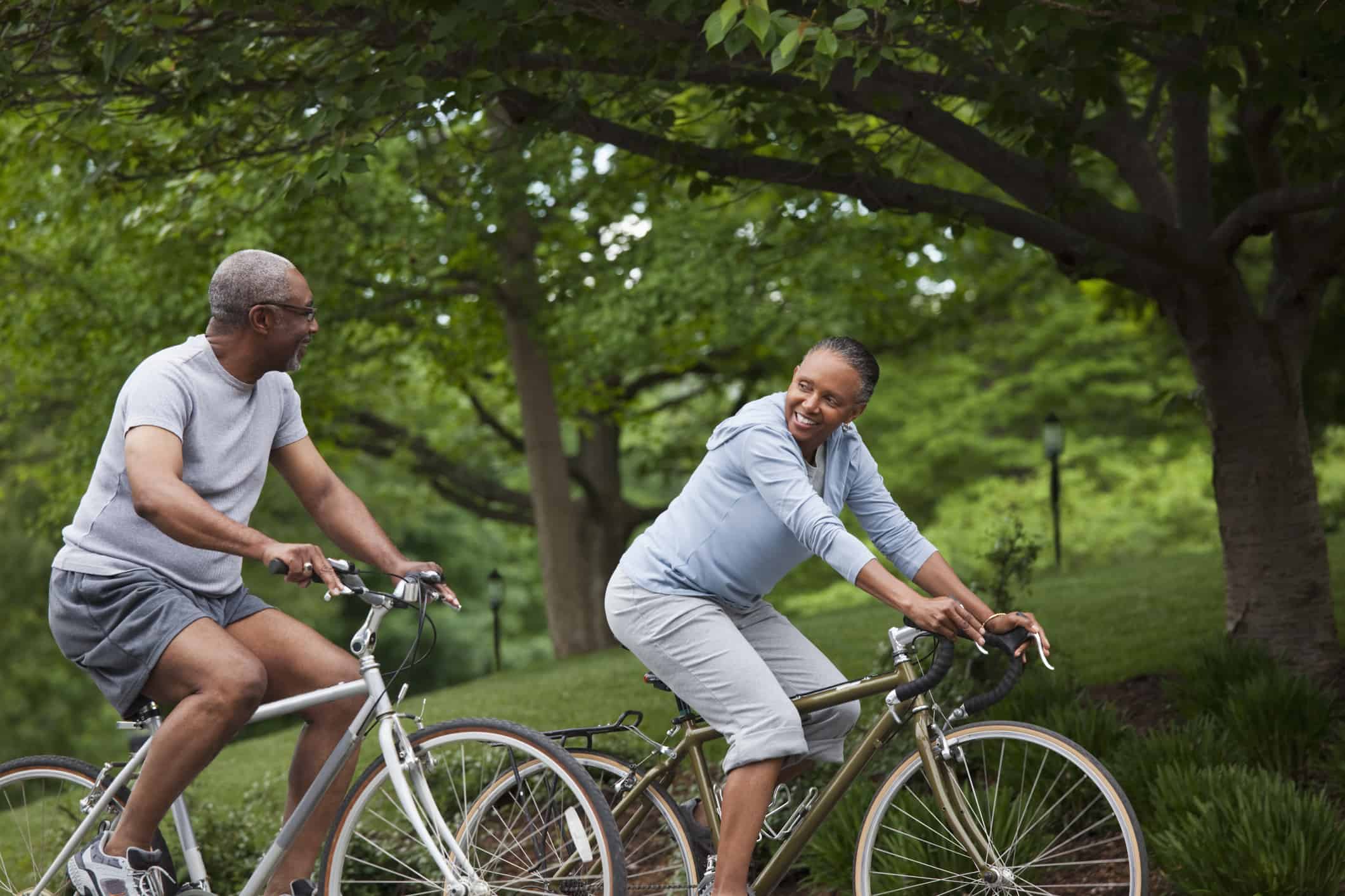 a man and woman riding on the back of a bicycle