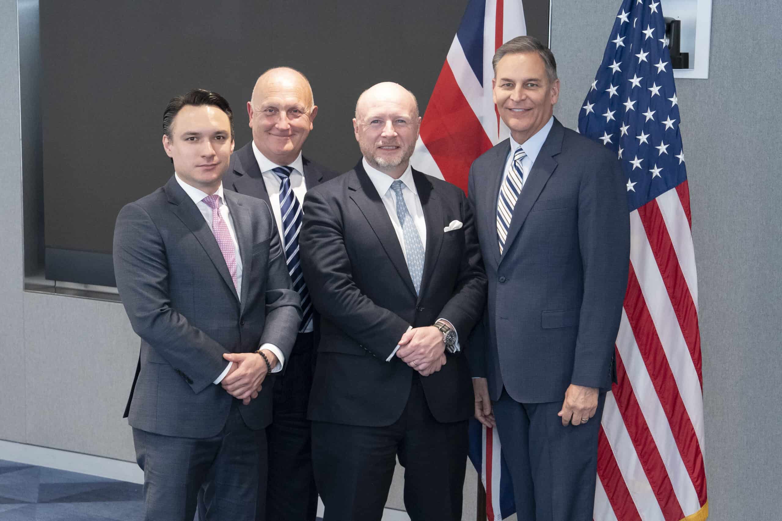 a group of people standing next to a man in a suit and tie