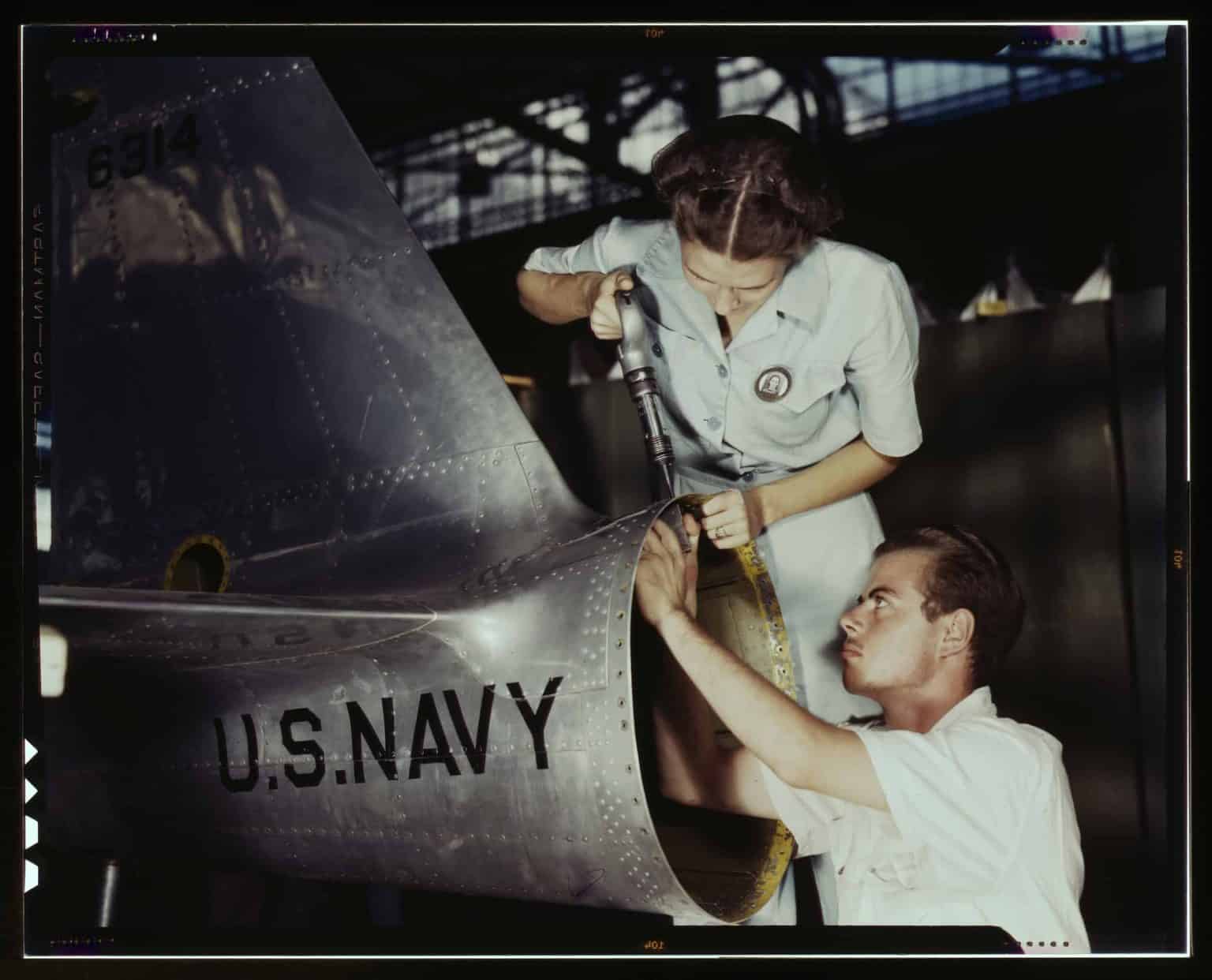 Old photo of man and woman working on manufacturing plant 
