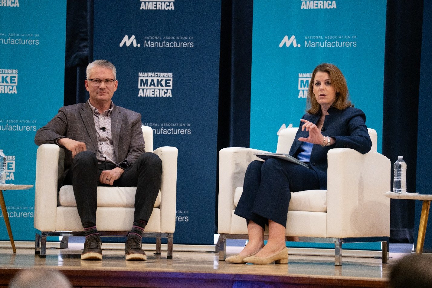 Two manufacturing executives in conversation on stage at an NAM Executive Edge forum